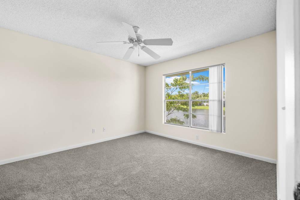 Bedroom with window and ceiling fan at Clipper Cove Apartments in Boynton Beach, Florida