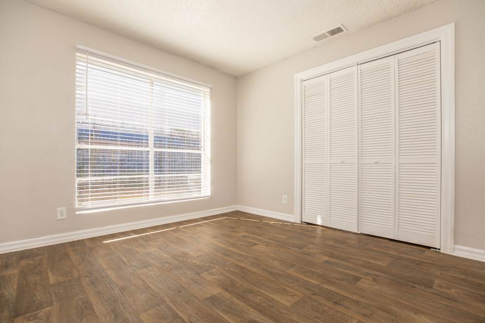 Spacious bedroom with walk-in closet and large windows at Fredericksburg Place Apartments in San Antonio, Texas,