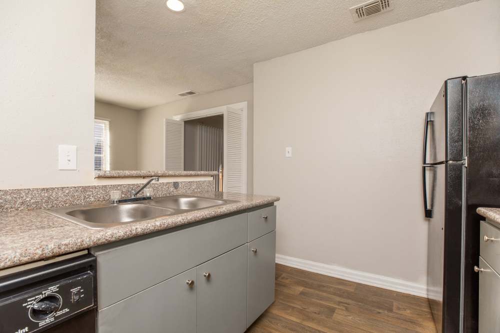 Kitchen with refrigerator at Fredericksburg Place Apartments in San Antonio, Texas