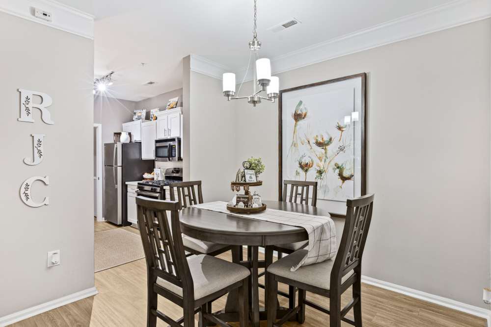  Dining room with a round table set for four, under a modern chandelier at Retreat at Johns Creek in Duluth, Georgia