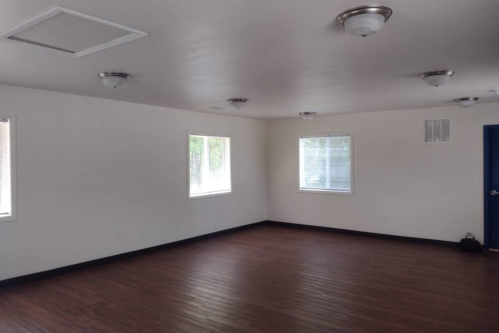 View of community room with large windows at Perry Acres Apartments in New Haven, Michigan