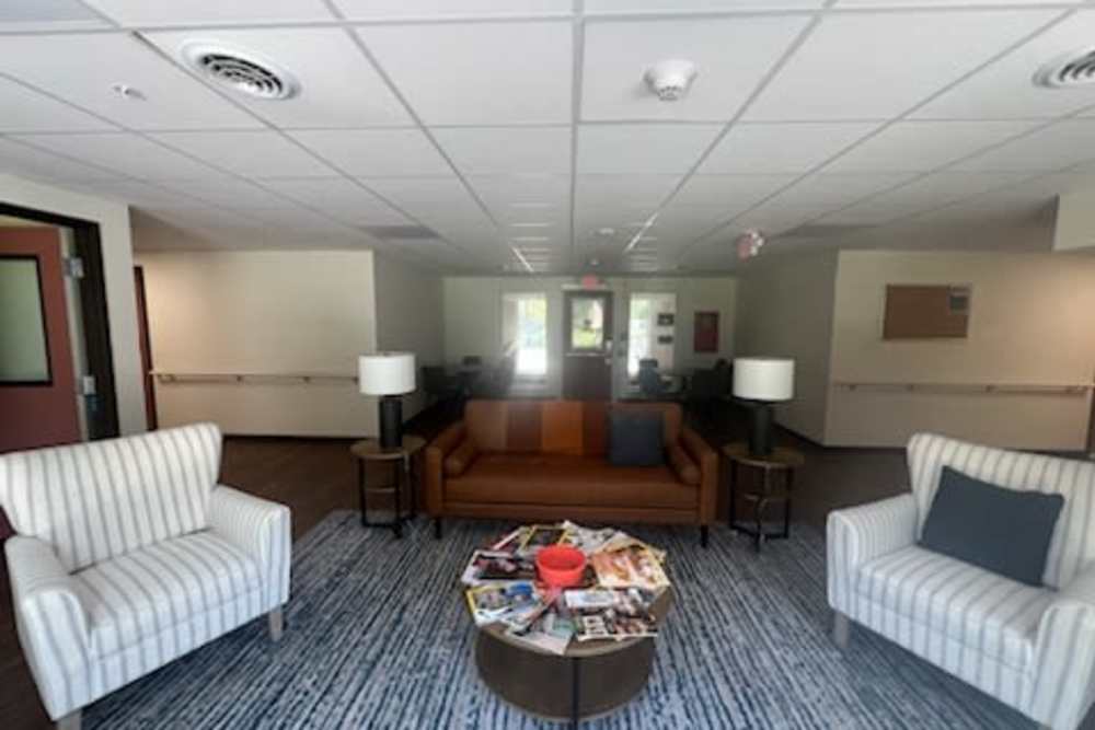 Clubhouse with sofa and side lamp at Rolling Brook Apartments in Algonac, Michigan