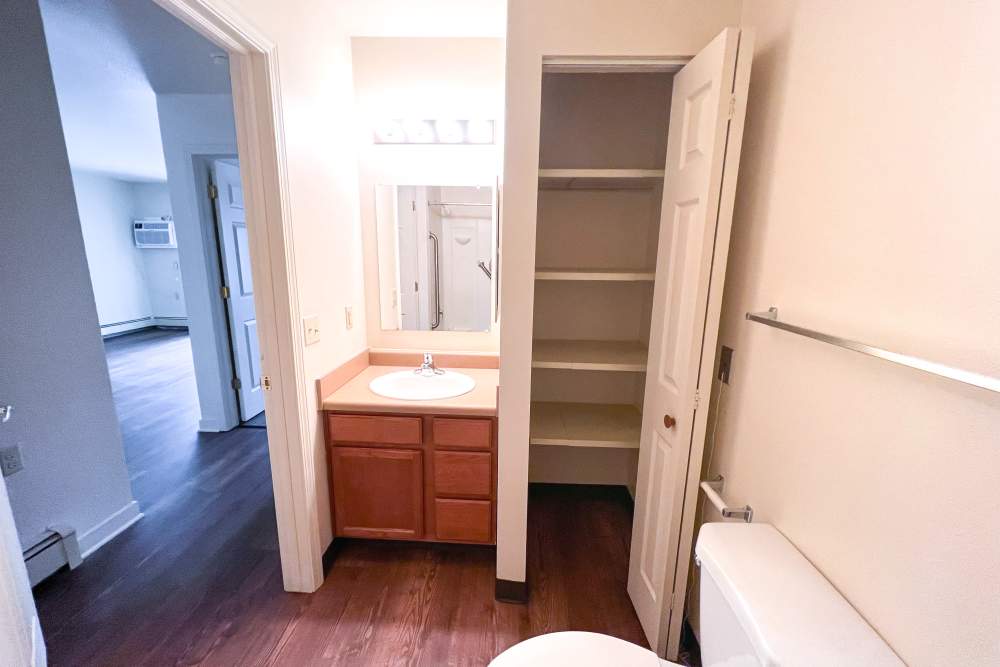 Bathroom with linen closet at Rolling Brook Apartments in Algonac, Michigan