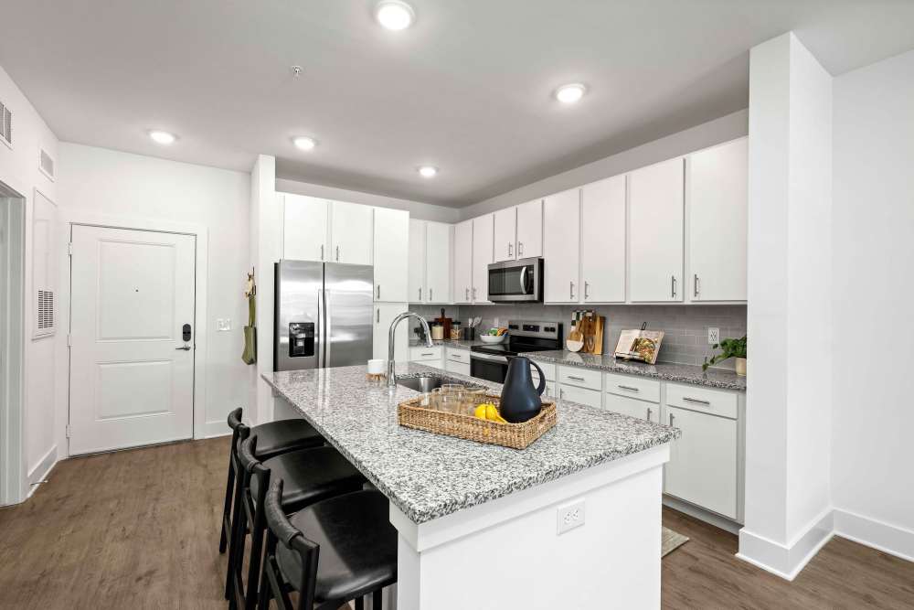 Kitchen with white cabinets and large island at The Maggie Flats in Jacksonville, FL