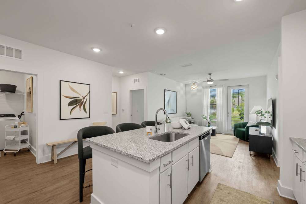 Kitchen with white cabinets and large island at The Maggie Flats in Jacksonville, FL