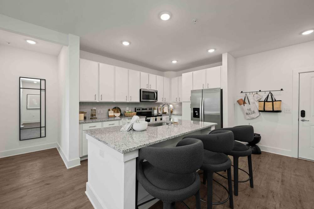 Kitchen with white cabinets and large island at The Maggie Flats in Jacksonville, FL