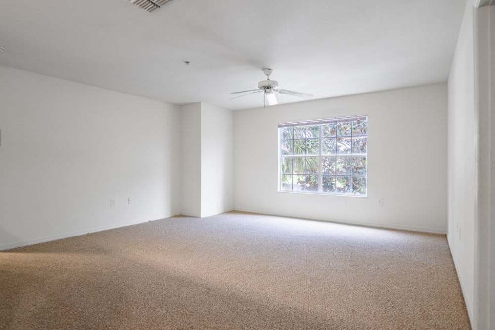 Bright living room with large windows and ceiling fan at Clarcona Groves in Orlando, Florida,