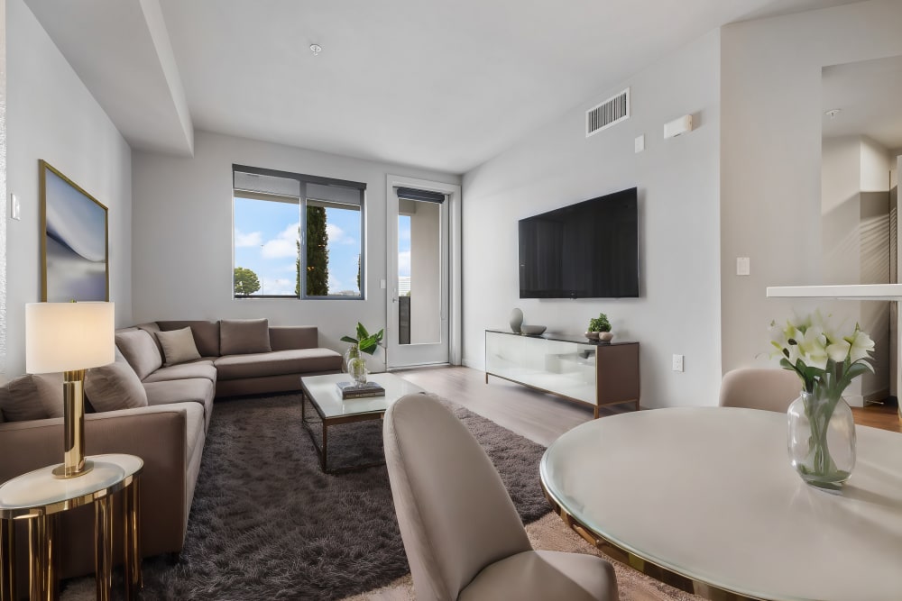 Dining table and living room at The George Apartment Homes in Anaheim, California