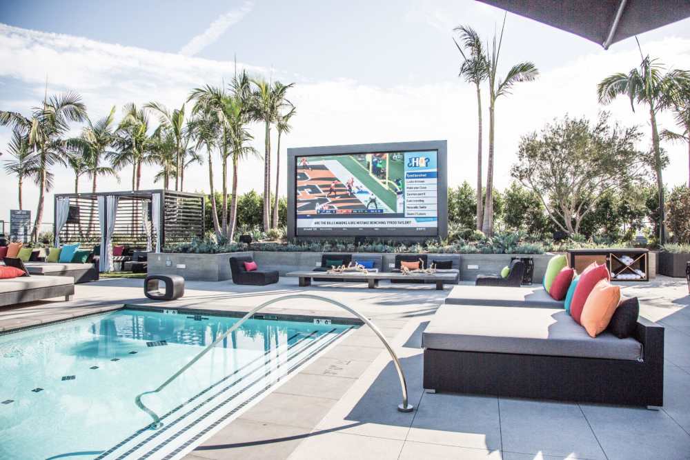 Chaise lounges by the pool at The George Apartment Homes in Anaheim, California