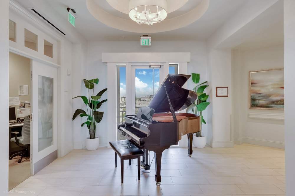 Grand piano in elegant lounge with ambient lighting at The Meridian at Waterways in Fort Lauderdale, FL