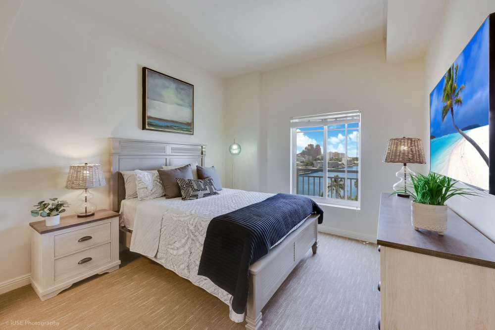 Peaceful bedroom with a large bed and window view at The Meridian at Waterways in Fort Lauderdale, FL