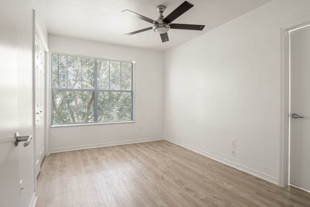 Bedroom with a large window and a ceiling fan at Cypress Commons in Wildwood, Florida