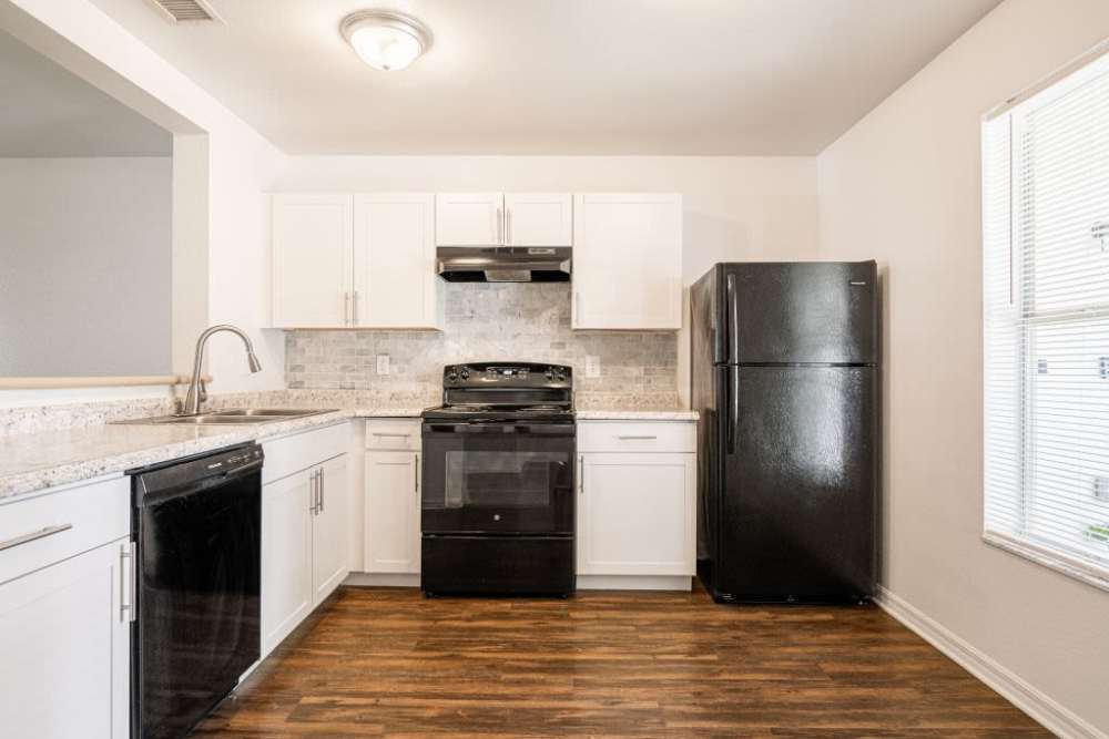 Modern kitchen with wooden cabinets at Cypress Commons in Wildwood, Florida
