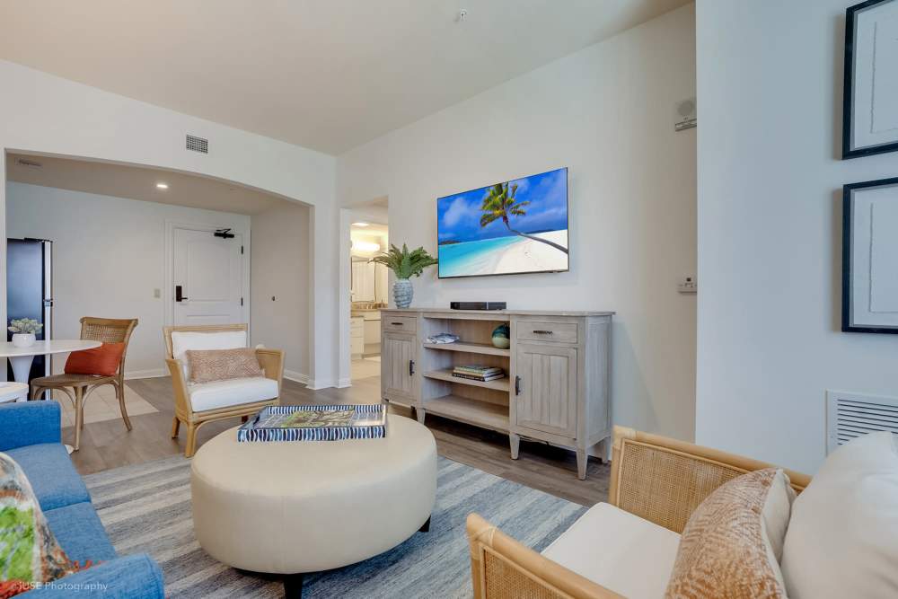A living room featuring blue furniture and a flat screen TV at The Meridian at Boca Raton in Boca Raton, Florida.