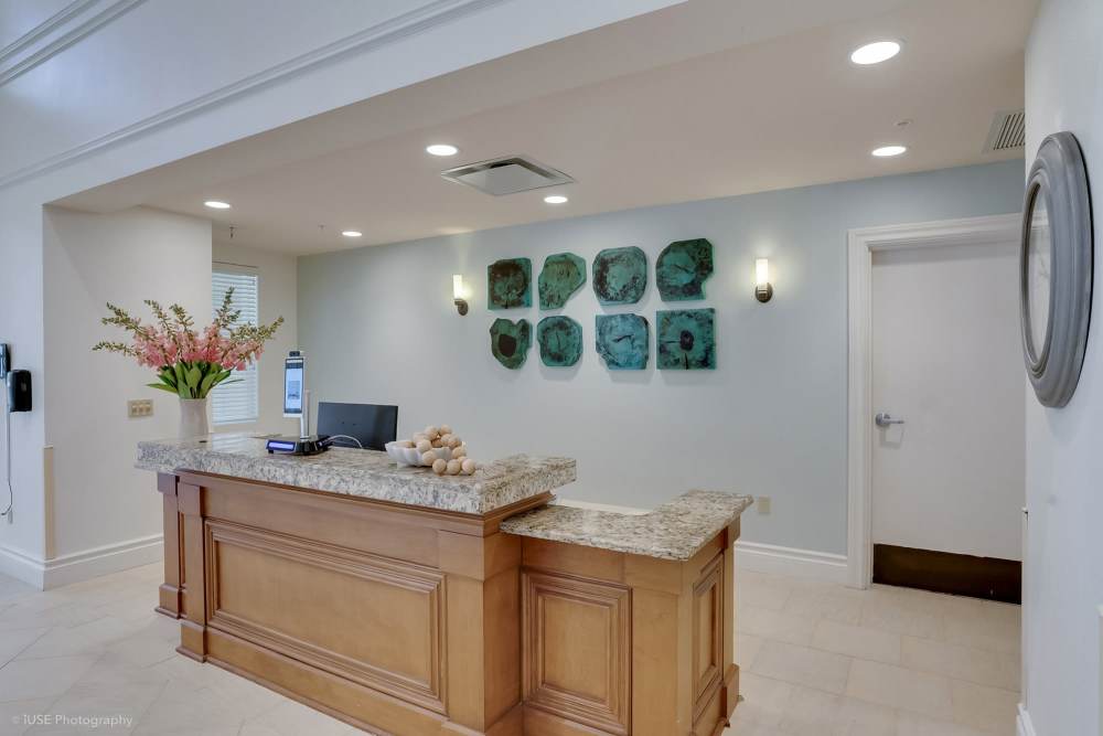 A reception desk in a white and beige room at The Meridian at Boca Raton in Boca Raton, Florida.