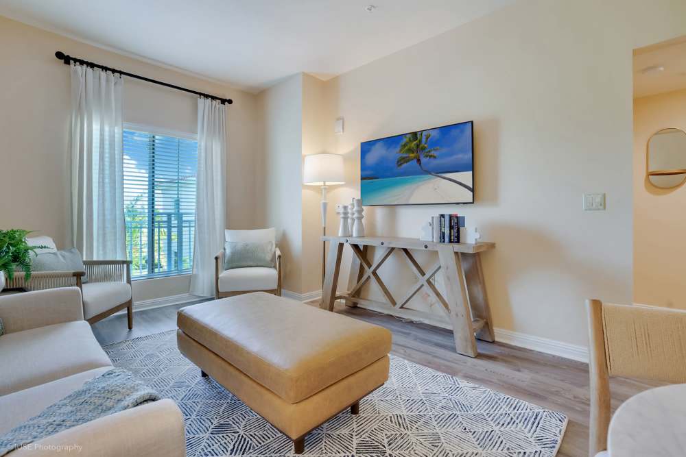 A spacious living room featuring a large flat screen TV, located at The Meridian at Boca Raton in Boca Raton, Florida.