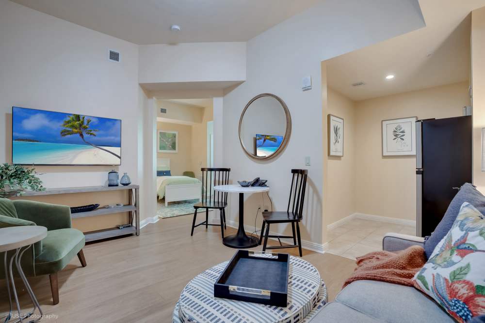 A cozy living room featuring a flat screen TV and a couch, located at The Meridian at Boca Raton in Boca Raton, Florida.