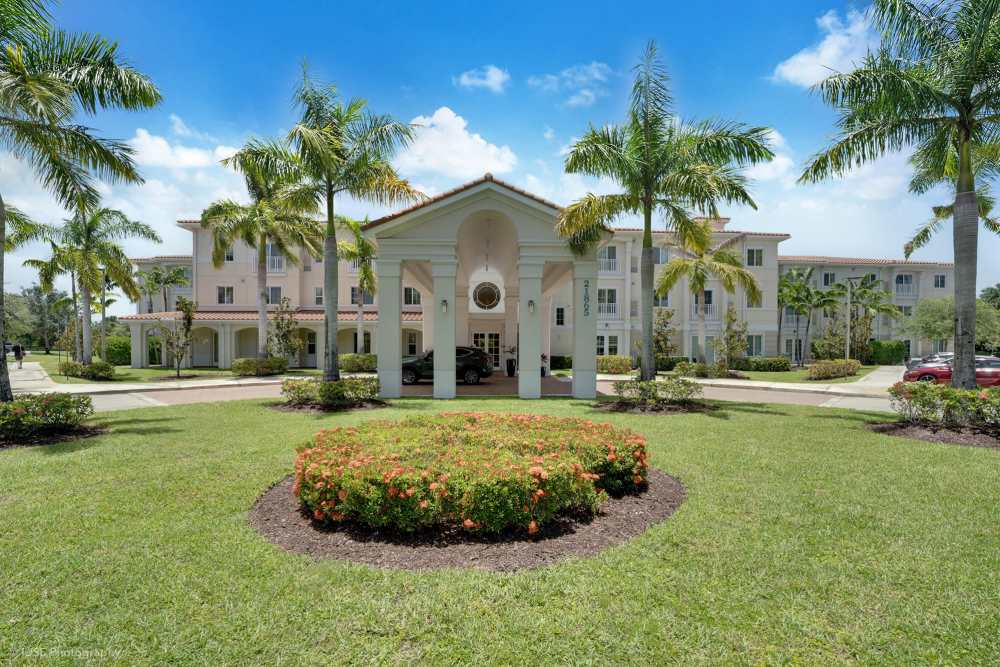 Front entrance of a large home surrounded by palm trees at The Meridian at Boca Raton, Boca Raton, Florida.