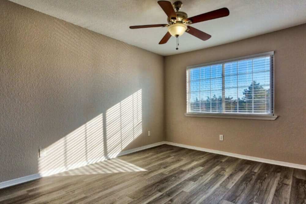 Spacious bedroom with large windows and wood-style flooring at Brookstone Park Of Seminole in Seminole, Oklahoma, 