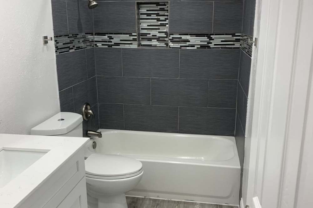 Bathroom with a toilet and a bathtub at Oak Manor Apartments in Henderson, Texas