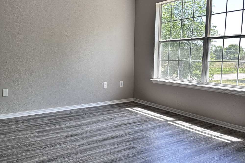 Living room with large window at Steeplechase in Coweta, Oklahoma