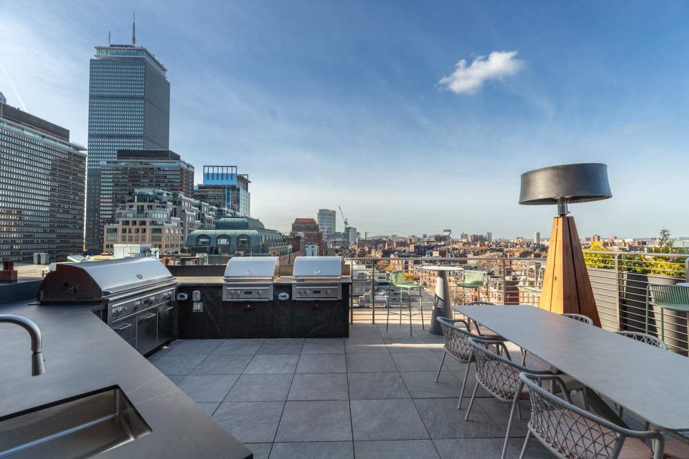 Rooftop pool with 'No Entry' sign, overlooking a cityscape with buildings under a clear blue sky at 28 Exeter at Newbury in Boston, Massachusetts