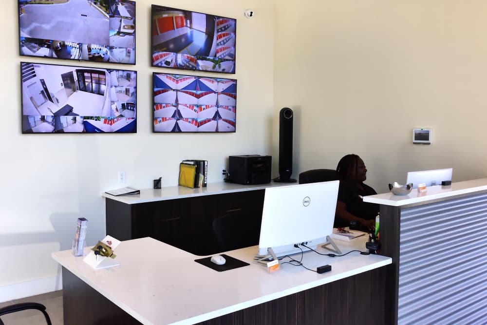 A reception area with a desk, computer monitors, surveillance screens, and office supplies, at Your Storage Units Clermont in Clermont, Florida.