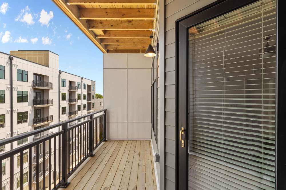 Spacious balcony with wooden flooring and views of surrounding buildings at Flats at College Park in College Park, Maryland