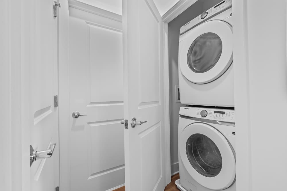 Compact laundry area with stacked washer and dryer at Flats at College Park in College Park, Maryland.