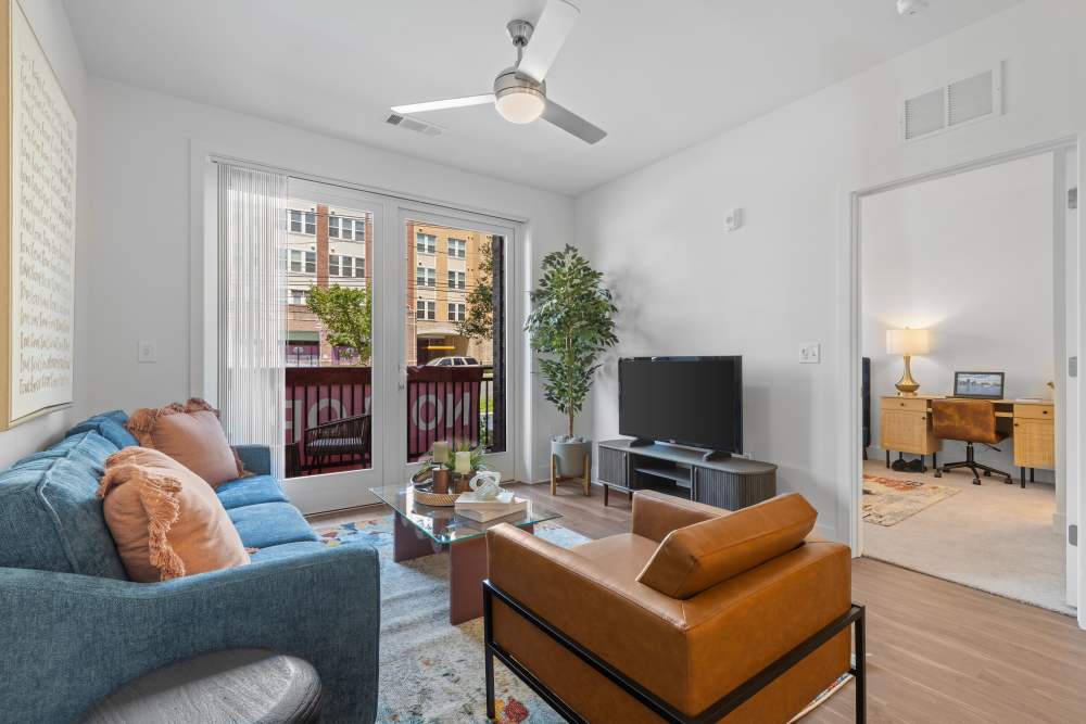 Inviting living room with balcony access and modern decor at Flats at College Park in College Park, Maryland.
