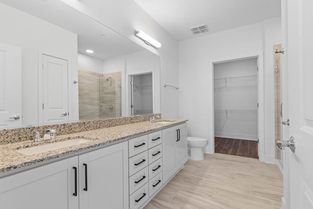 Spacious bathroom with dual sinks and modern design at Flats at College Park in College Park, Maryland