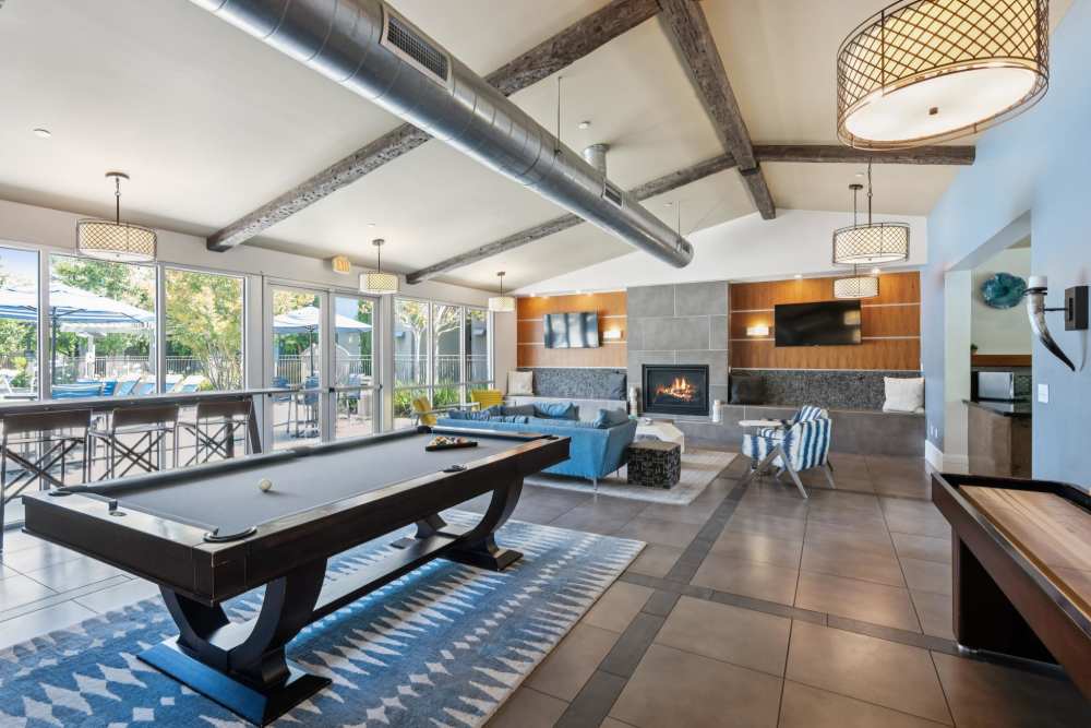 Clubhouse with fireplace, seating, and billiards at Azure Apartment Homes in Petaluma, California
