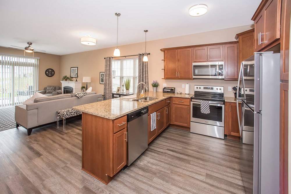 Kitchen and living room with wood-style flooring at Fox Creek Estates in East Amherst, New York