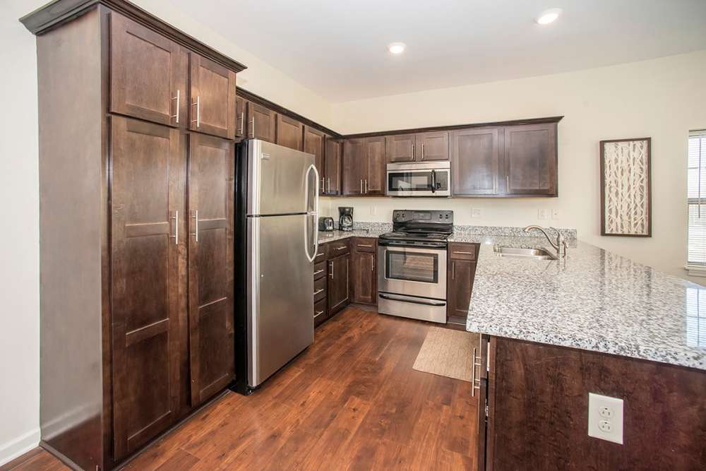 Kitchen with wood-style flooring and dark cabinetry at Fox Creek Estates in East Amherst, New York