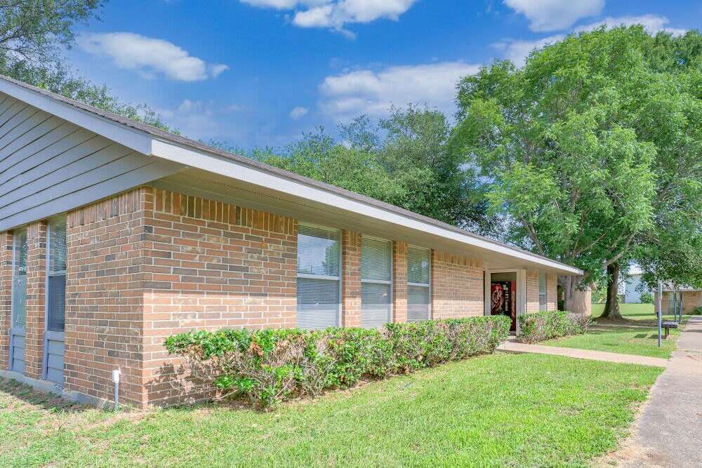 Building exterior with a lawn at Grapeland Apartments in Grapeland,Texas