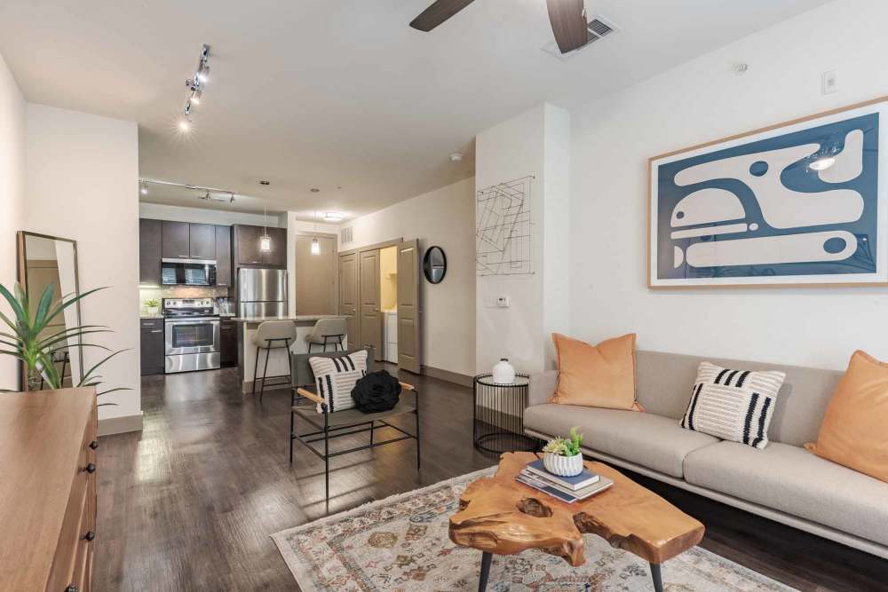 Living room scene with a couch, chair, and TV, located at Henley at The Rim in San Antonio, Texas.