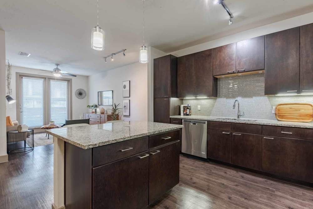 Elegant kitchen featuring stainless steel appliances and wood floors at Henley at The Rim in San Antonio, Texas.