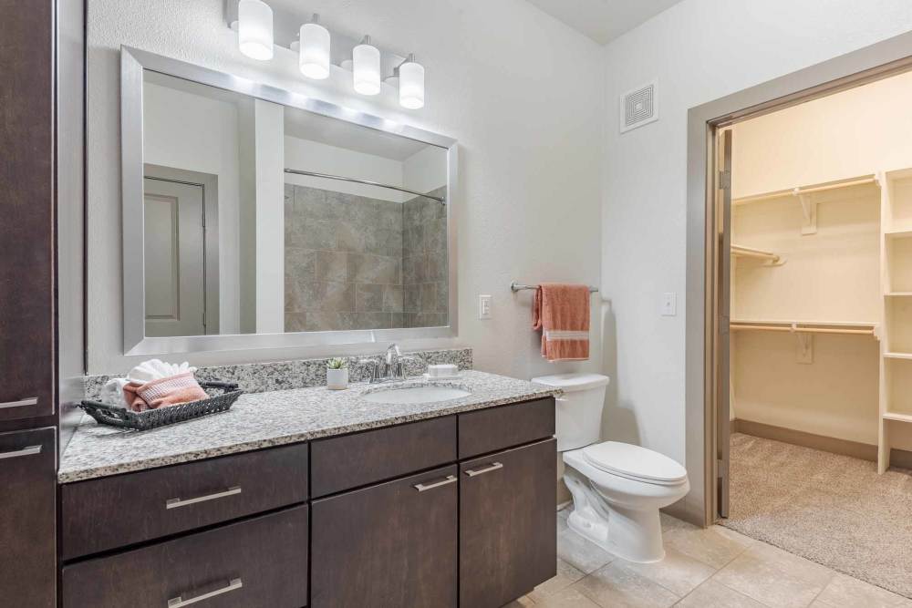 A bathroom featuring a sink, toilet, and cabinets at Henley at The Rim in San Antonio, Texas.