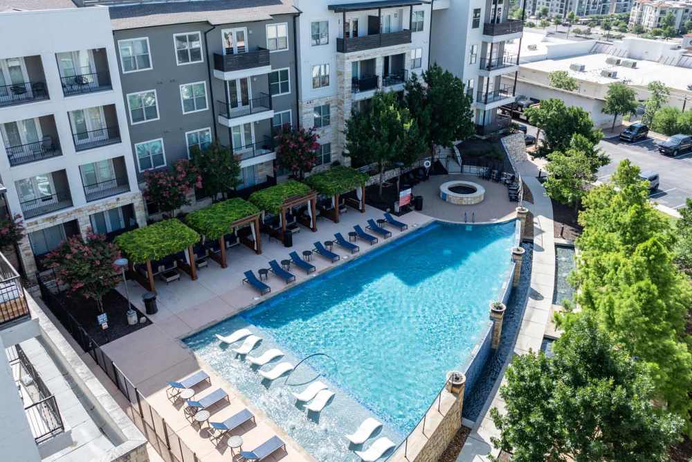 Aerial view of a pool surrounded by apartment buildings at Henley at The Rim in San Antonio, Texas.