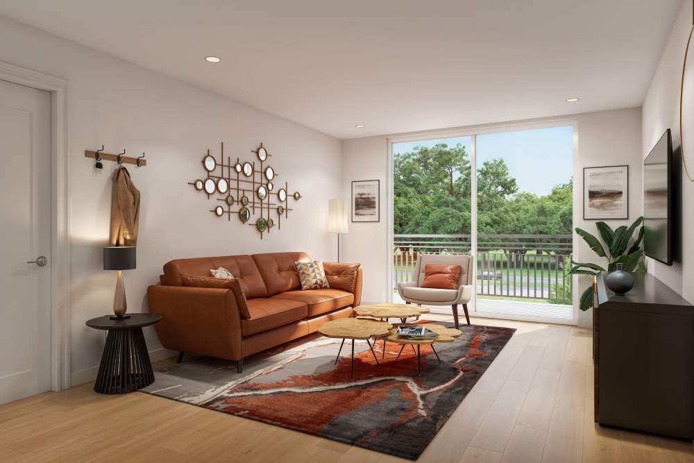Stylish living room with a brown leather sofa, a round coffee table, decorative wall art, and large sliding glass doors leading to a balcony, creating a bright and inviting atmosphere at The Renaissance in Naples, Florida