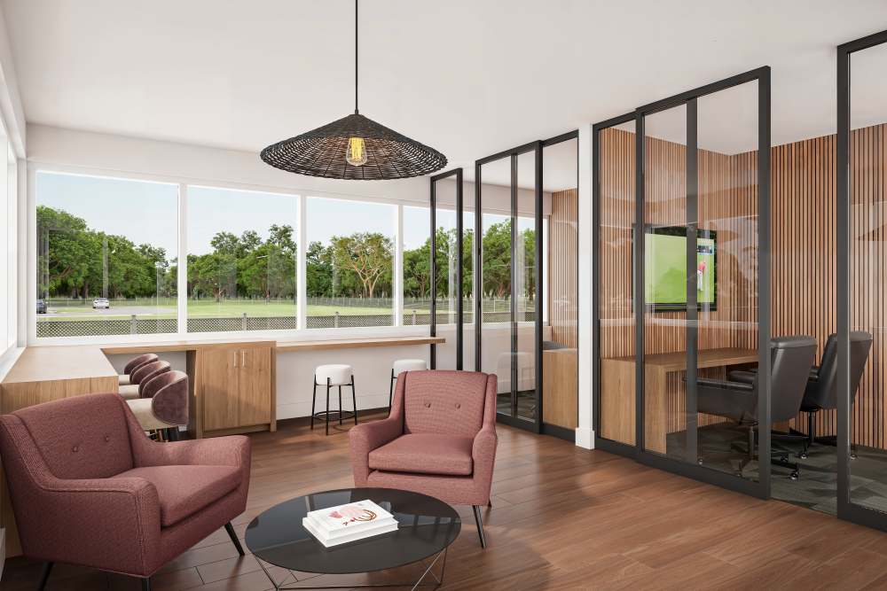 Contemporary co-working space featuring comfortable seating, a glass-walled conference room, and large windows that offer a view of the outdoors, fostering a productive atmosphere at The Renaissance in Naples, Florida.