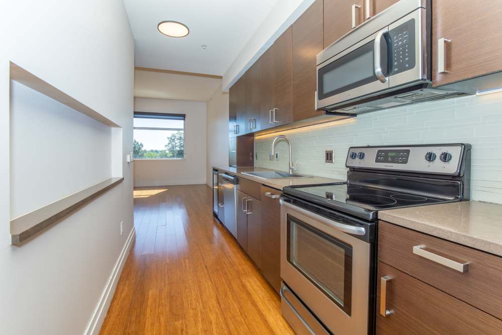 Kitchen with wooden cabinets and stainless-steel appliances at The View at Wash Park in Denver, Colorado