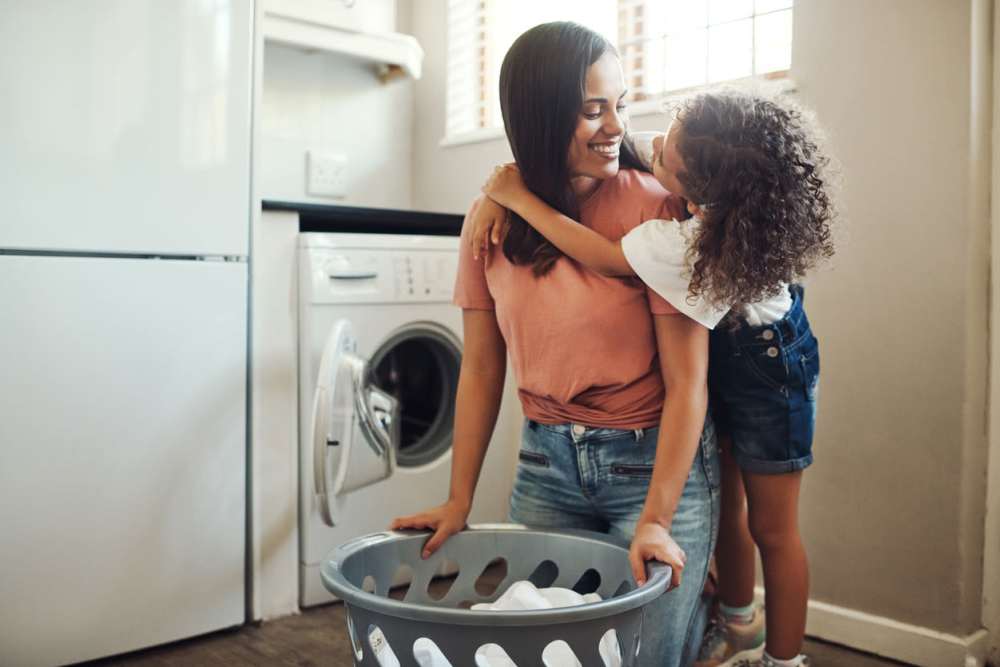 Happy woman washing clothes with her kid at Union at the Park in Denver, Colorado