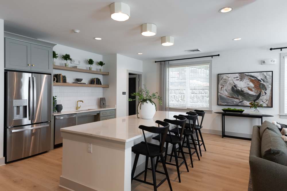 A modern kitchen featuring a white countertop and sleek stainless steel appliances at The Pines At Peach Road in Raleigh, North Carolina