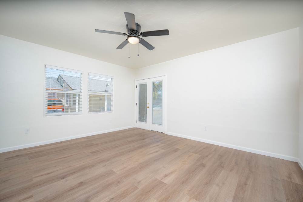 Spacious room with high ceilings, a ceiling fan, and mirrored closet doors, featuring light-colored walls and flooring, at Copa Cabanas in Santa Cruz, California