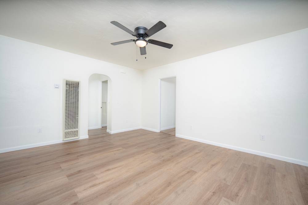 Spacious room with high ceilings, a ceiling fan, and mirrored closet doors, featuring light-colored walls and flooring, at Copa Cabanas in Santa Cruz, California