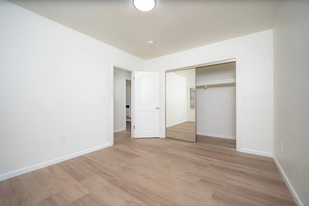 Spacious empty room featuring light-colored walls and flooring, with open doorways leading to additional spaces, at Copa Cabanas in Santa Cruz, California.