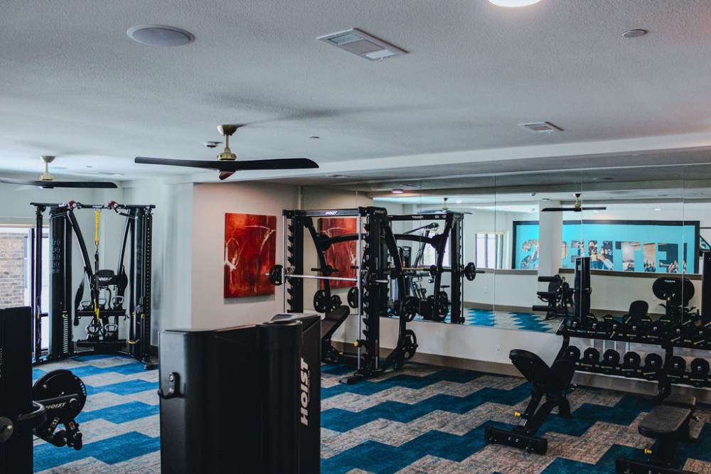 Resident working out in the fitness center at The Heyward Apartments in Corinth, Texas