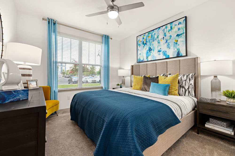 Apartment bedroom with large sunlit window and queen-size bed at Vue on Lake Monroe in Sanford, Florida