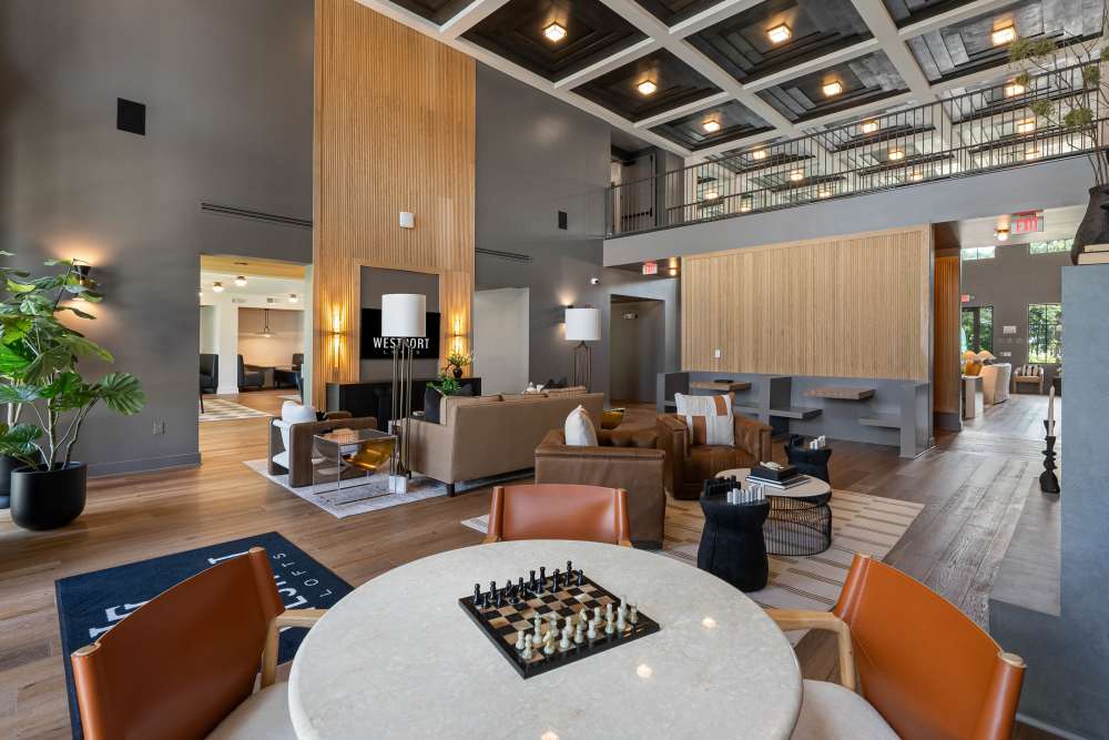 Modern lobby with high ceilings, seating areas, and a chess table at Westport Lofts in Belville, North Carolina